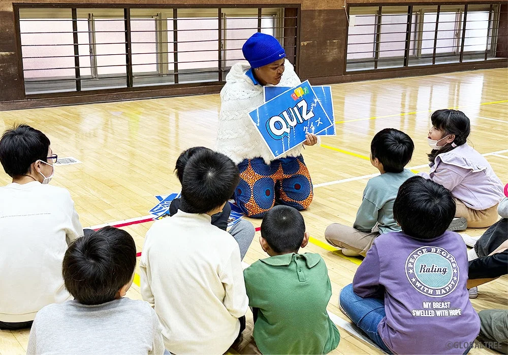 体育館で子供たちにクイズを説明する大人