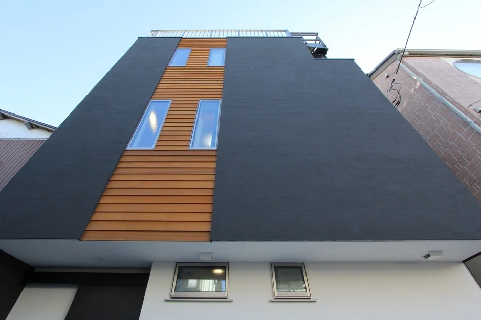 黒い壁と木目調のパネルが印象的な現代的な建物の外観