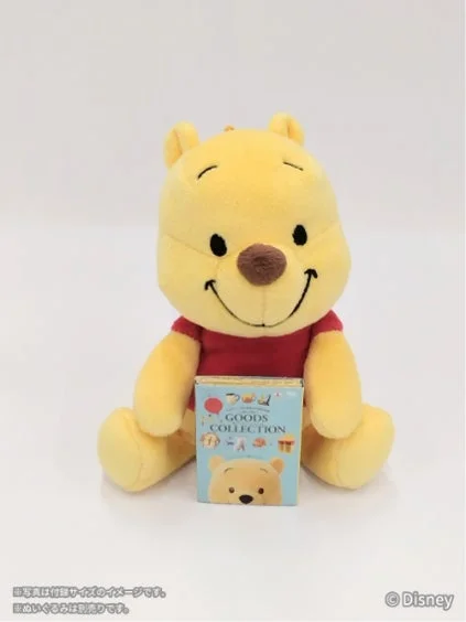 プーさんのぬいぐるみがミニチュア本を持つ様子