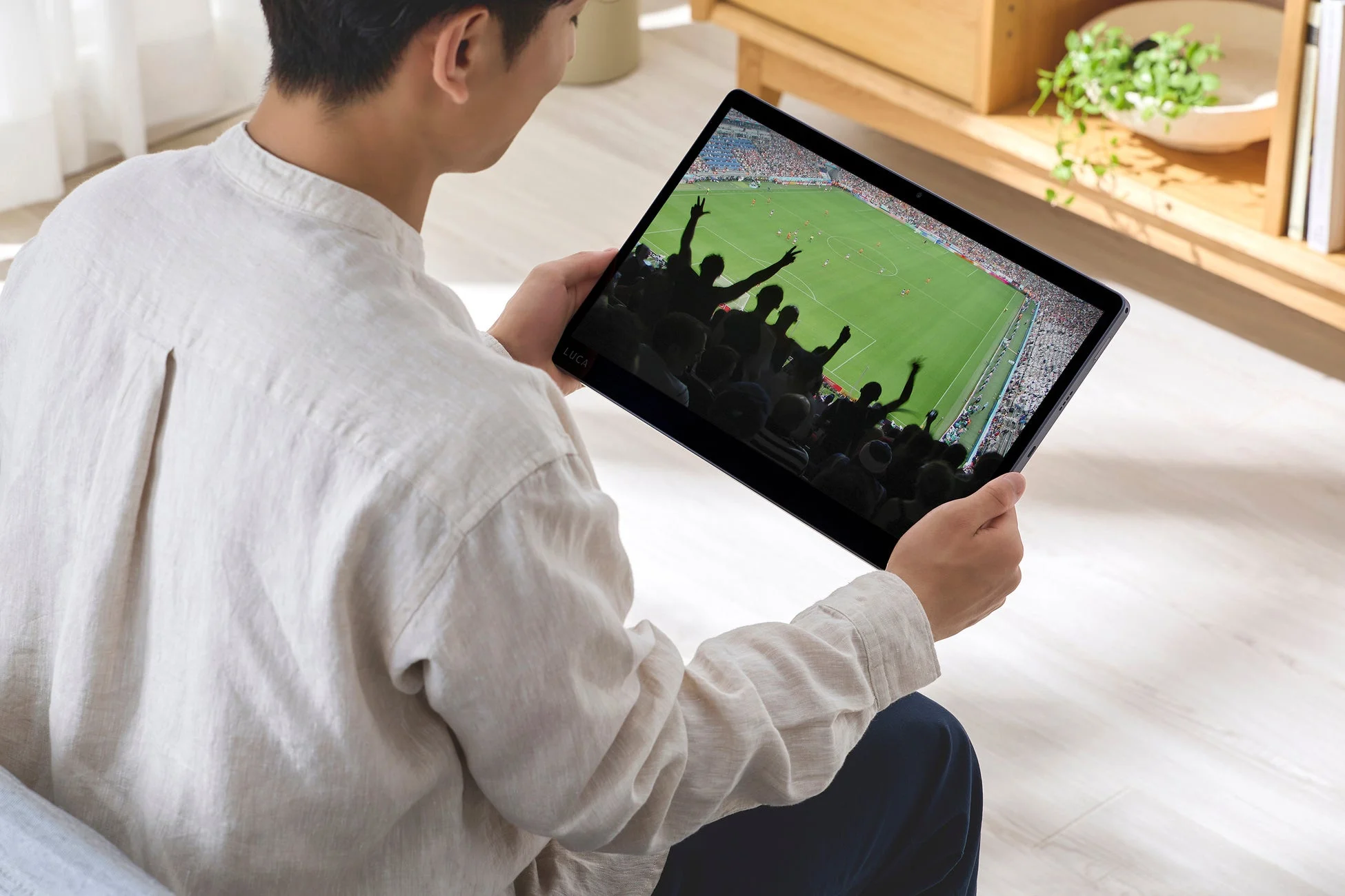 サッカー観戦をする男性とタブレット