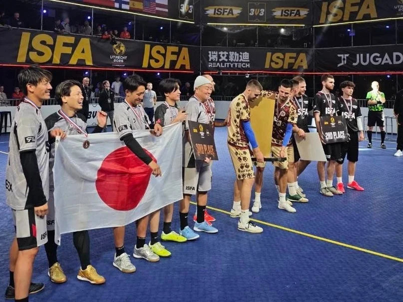 ISFA国際大会の表彰式で日の丸を掲げ笑顔を見せる日本代表チーム