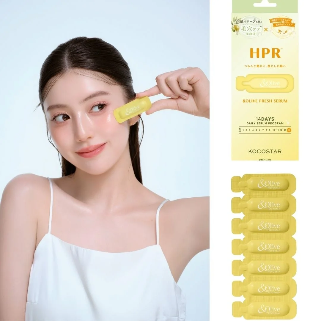 女性が「&Olive FRESH SERUM」の美容液アンプルを顔に塗布している画像です。製品パッケージには、完熟オリーブの恵みによる毛穴ケアとキメを整える効果、14日間のデイリーセラムプログラムであることが示されています。肌に艶と透明感を与えることを謳っています。