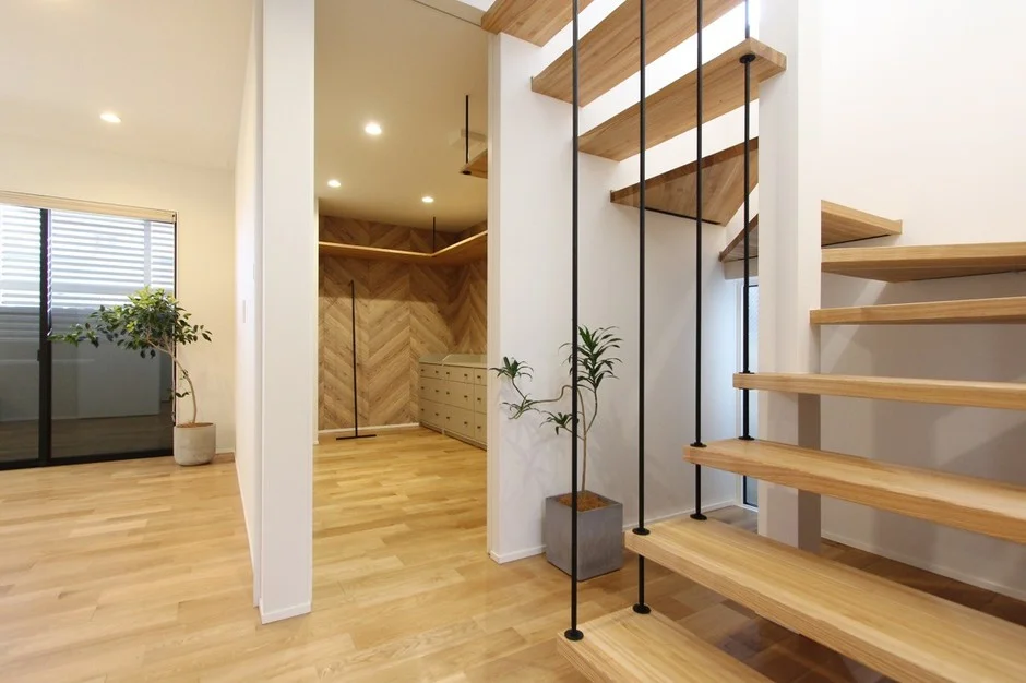明るい木目のフローリングと開放的な吹き抜けのモダンな住宅インテリア