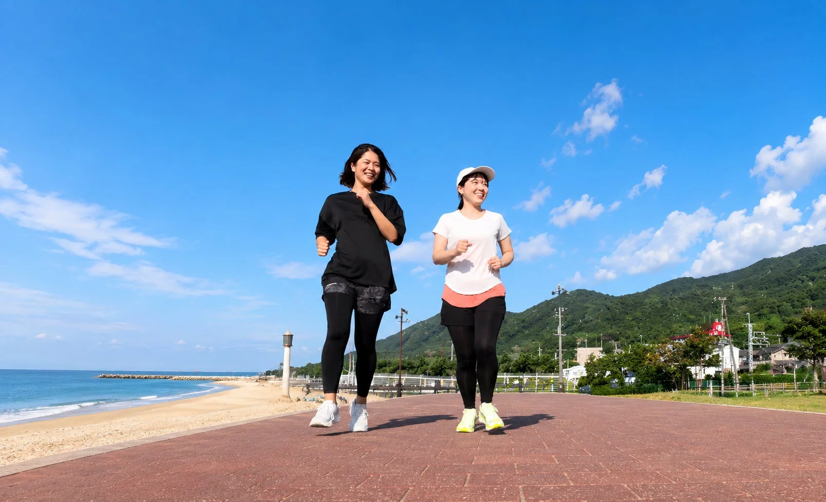 ビーチ沿いをジョギングする女性たち