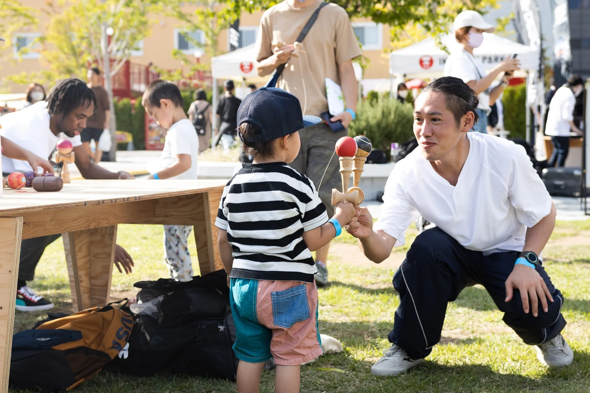 けん玉を教える大人と子供