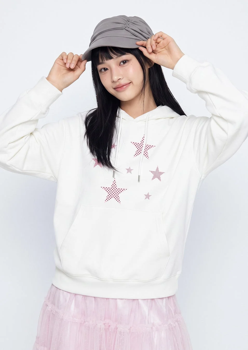 星柄パーカーとピンクのチュールスカートを着た若い女性