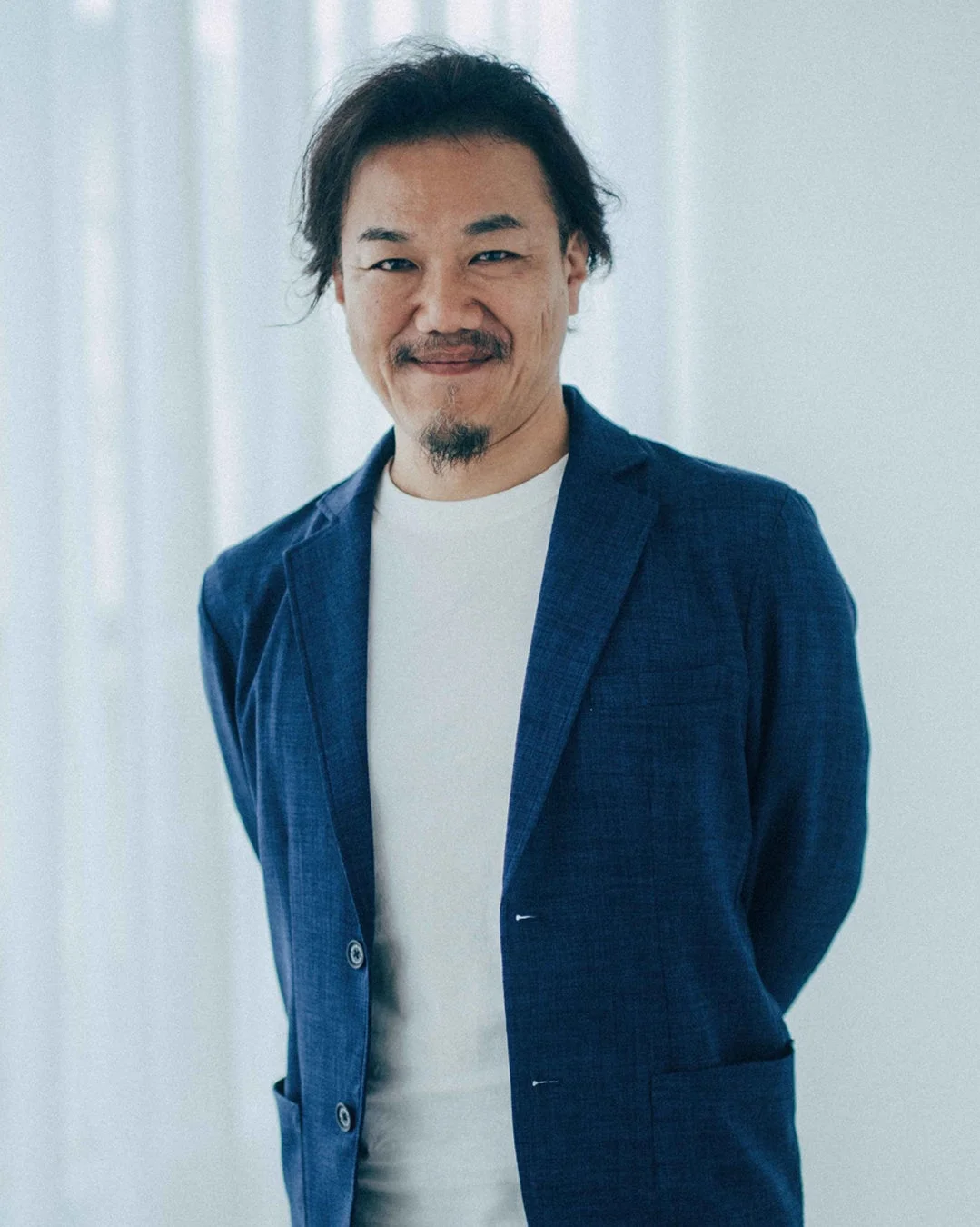 青いジャケットと白いTシャツを着たアジア人男性のポートレート