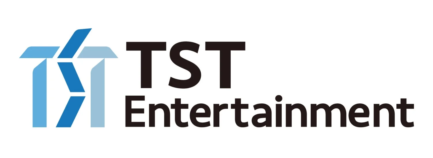白背景に「TST Entertainment」の文字と青い抽象的なグラフィックが配置されたロゴマークです。