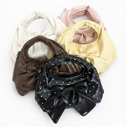 リボンが特徴的な様々な色のハンドバッグが5つ並んでいます。黒のドット柄を含む、かわいらしいデザインのバッグです。