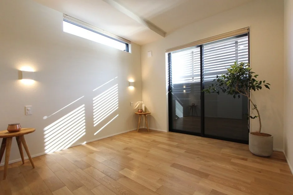 明るいフローリングと白い壁のモダンな部屋