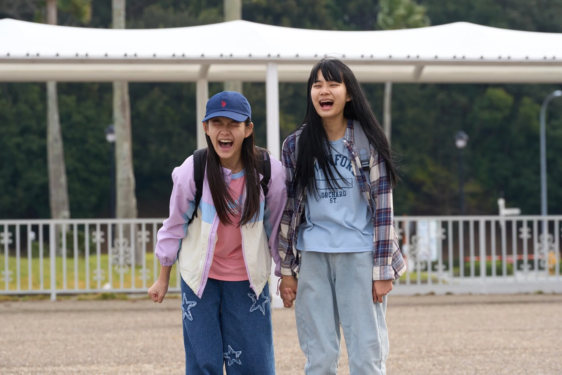 手をつないで笑顔で歩く二人の少女