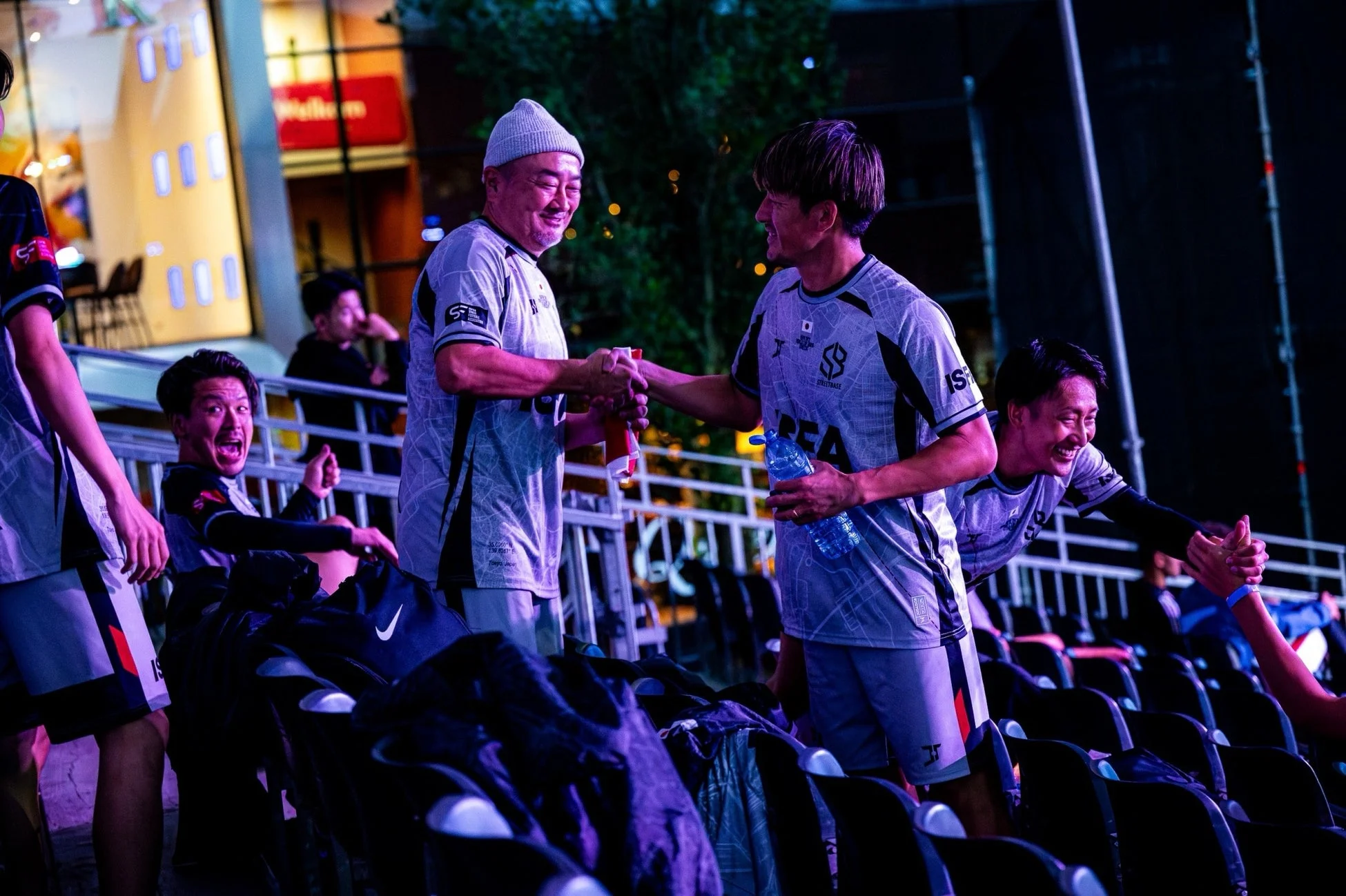 夜のスポーツイベントで交流する男性たち